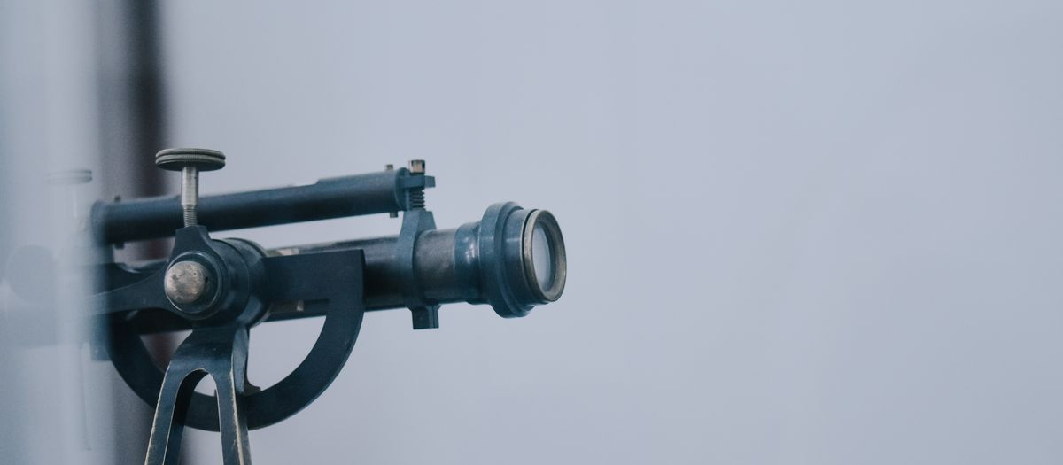 A close-up view of a vintage telescope lens showcasing intricate details and metal components.