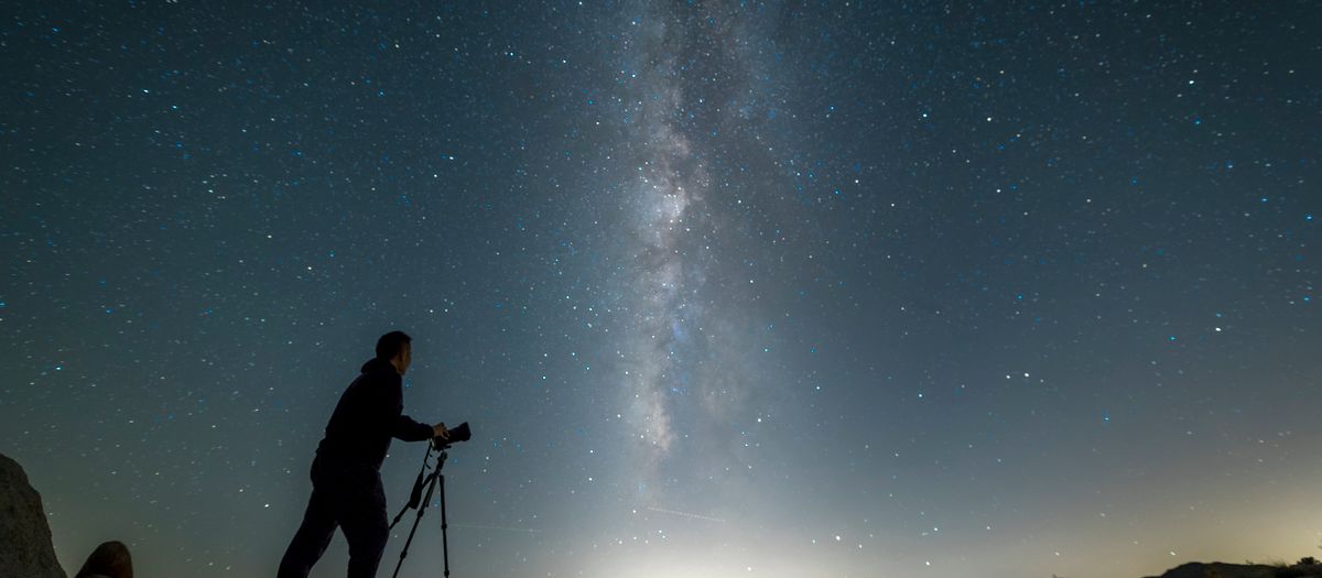Photographer capturing the stunning Milky Way galaxy in a California desert night sky.